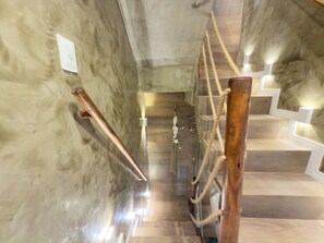 A staircase with wooden handrails and a rope barrier.