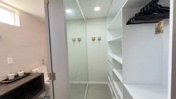 A modern bathroom with a toilet, a vanity with storage, and a glass shower enclosure.
