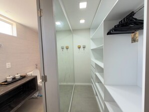 A modern bathroom with a toilet, a vanity with storage, and a glass shower enclosure.
