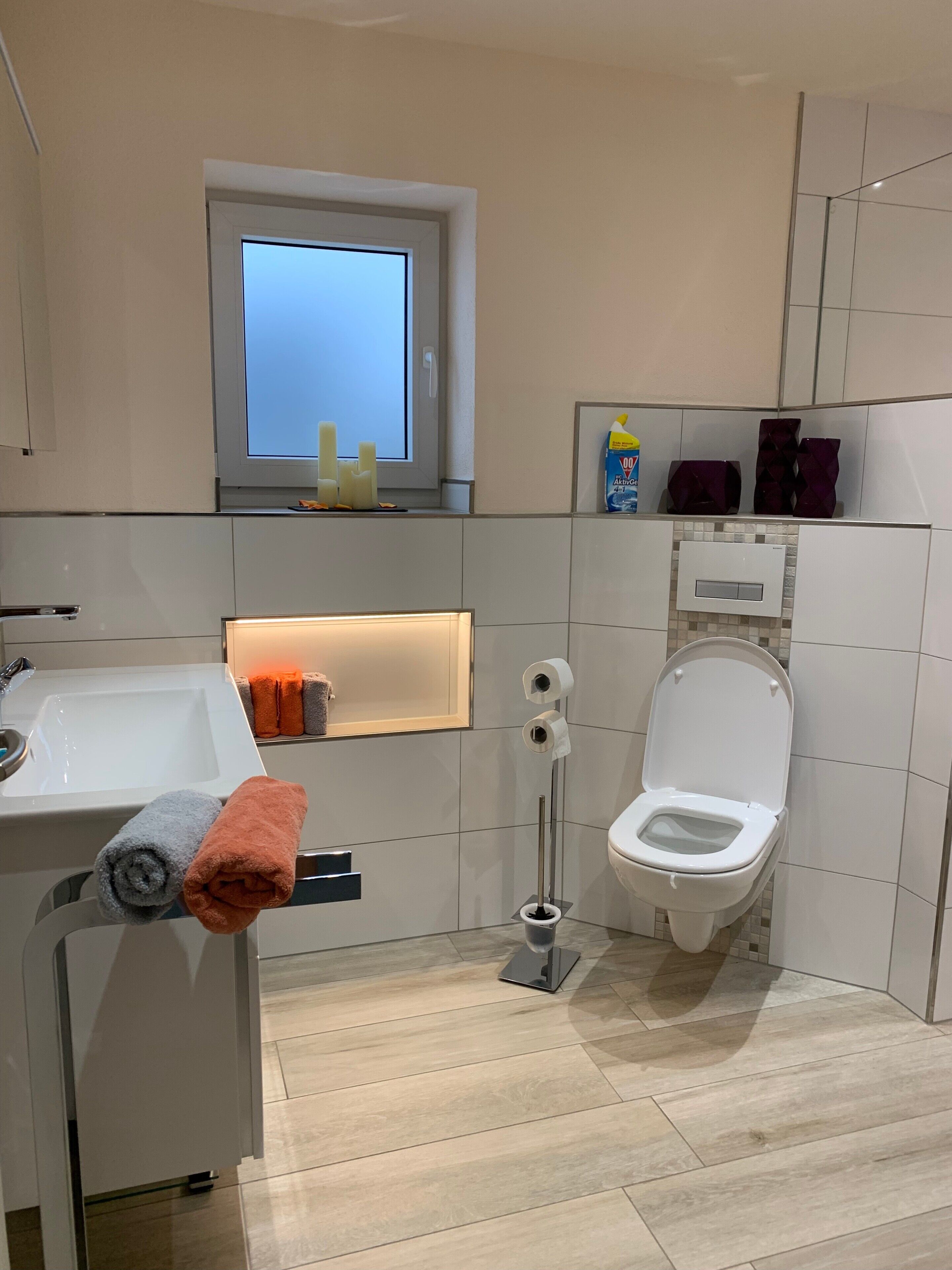 Un bagno moderno con il water, un lavandino e una finestra.