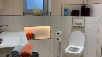 Un bagno moderno con il water, un lavandino e una finestra.