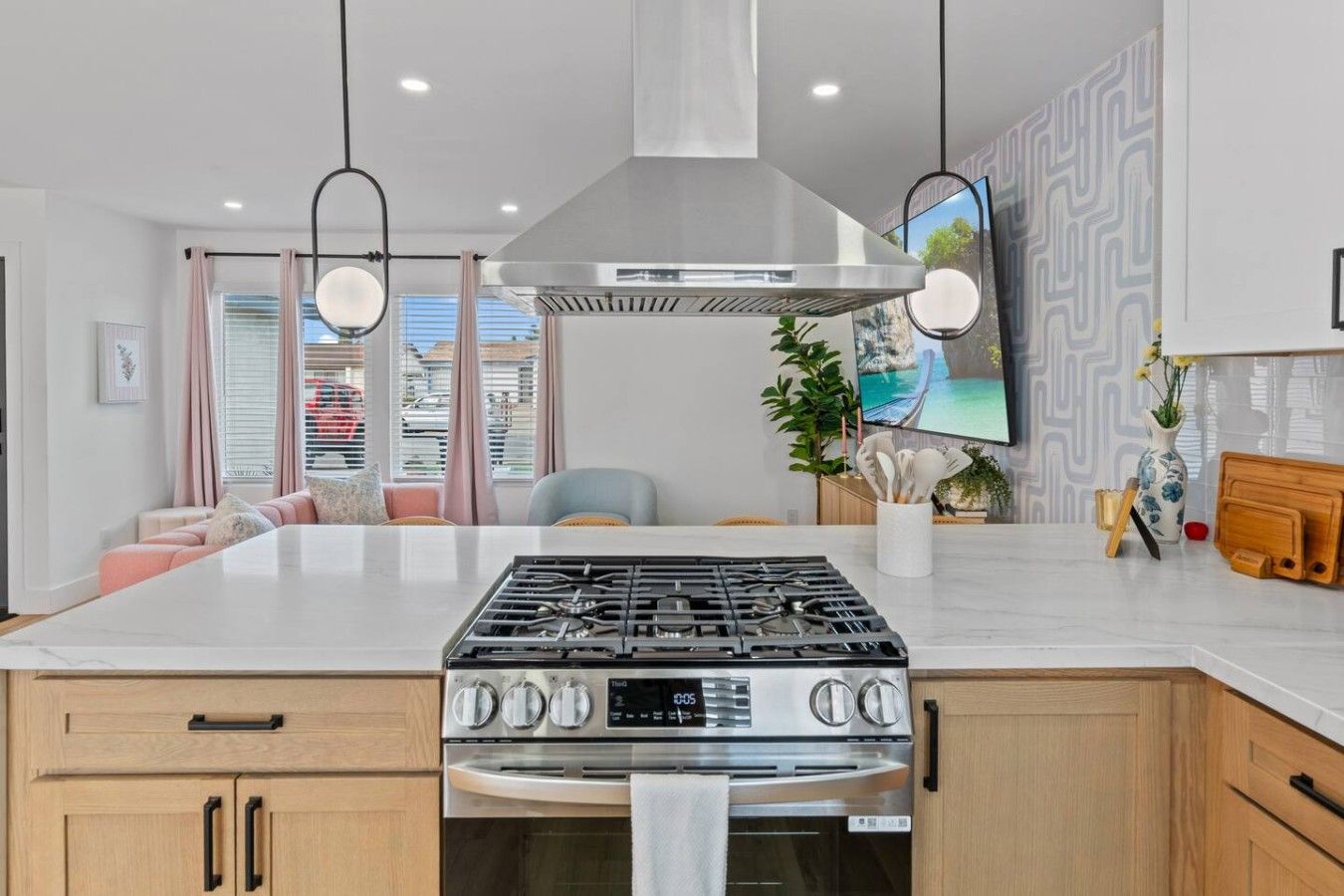 Una cocina moderna con una isla central, electrodomésticos de acero inoxidable y vistas a la ciudad.