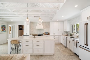 A spacious kitchen with a large island, white cabinetry, and a speckled floor. - St Pete Beach Vina Del Mar Waterfront Pool (St Pete Beach)