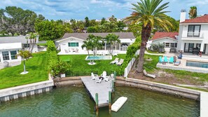 A residential property with a swimming pool, a dock, and a well-maintained lawn. - St Pete Beach Vina Del Mar Waterfront Pool (St Pete Beach)
