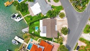 Una propietat residencial amb piscina, moll per a vaixells i carretera al costat.