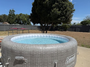 An inflatable pool with a wicker texture, a visible brand name, and a pump handle. - The 90s Clubhouse: Hot Tub + Games + Fam Friendly (San Diego)
