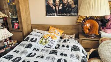 Una camera da letto con un letto, un quadro appeso al muro, una lampada e un comò.