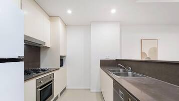 Una cocina moderna con electrodomésticos de acero inoxidable, horno empotrado y pileta doble.
