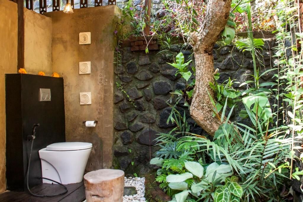 Ein Badezimmer mit Toilette, Dusche und einer Steinwand.