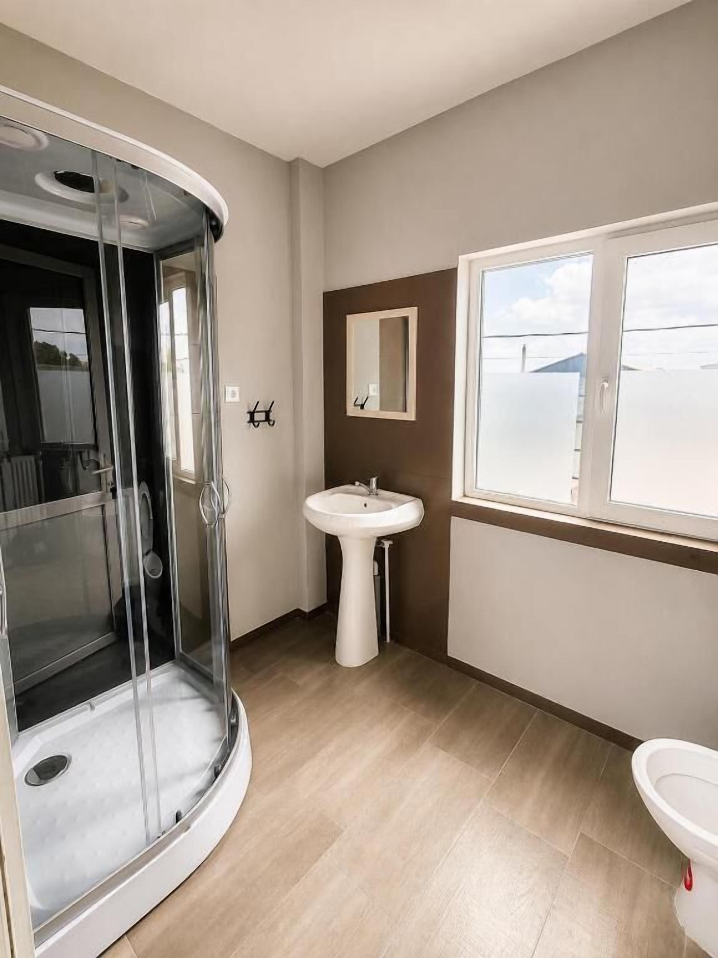 Ein Badezimmer mit Duschkabine, Waschbecken und Toilette.