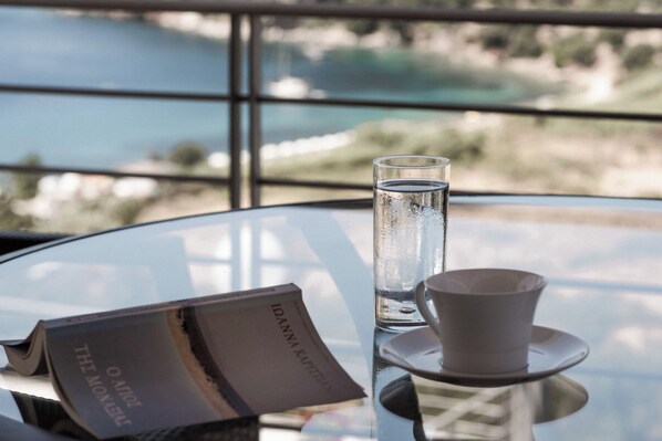 A table with a glass of water, a cup, and a menu. - Villa Idylle | Ithaca Greece (Ithaki)