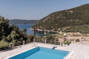 A swimming pool with a view of a coastal area and hills. - Villa Idylle | Ithaca Greece (Ithaki)