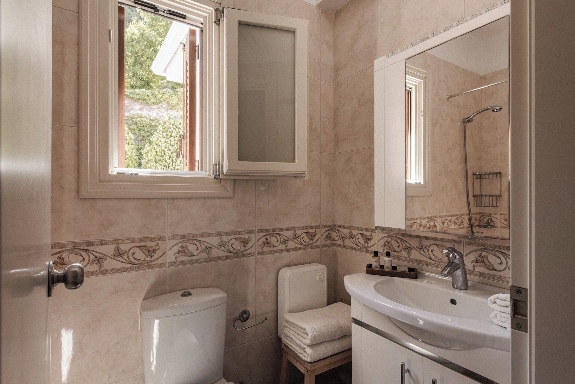 Un bagno con il water, un lavandino e uno specchio.