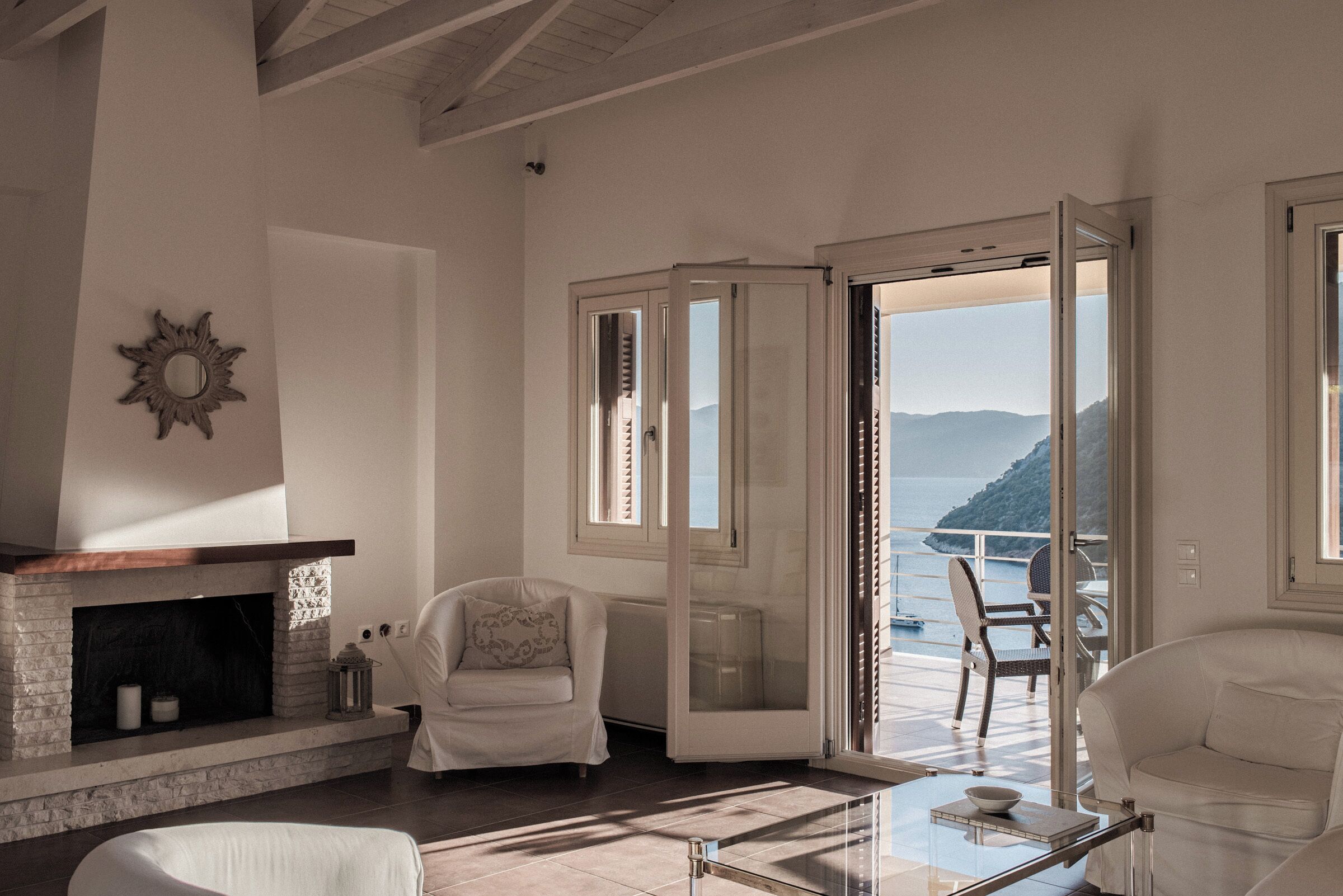 Un salón amplio con chimenea, un espacio de descanso cómodo y vistas al mar.