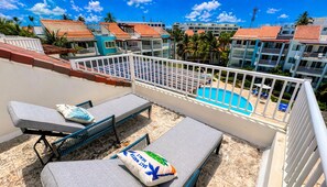 Eine Dachterrasse mit Lounge-Möbeln und einem Pool.
