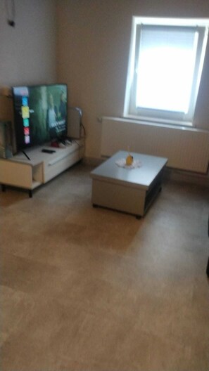 A living room with a flat-screen TV, a white coffee table, and a window. - 🍋 Casa Limone – Your cozy retreat in the Westerwald (not Upland) (Willingen)