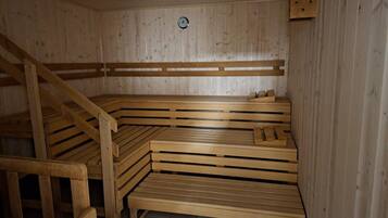 A sauna with wooden benches and a sloped ceiling.
