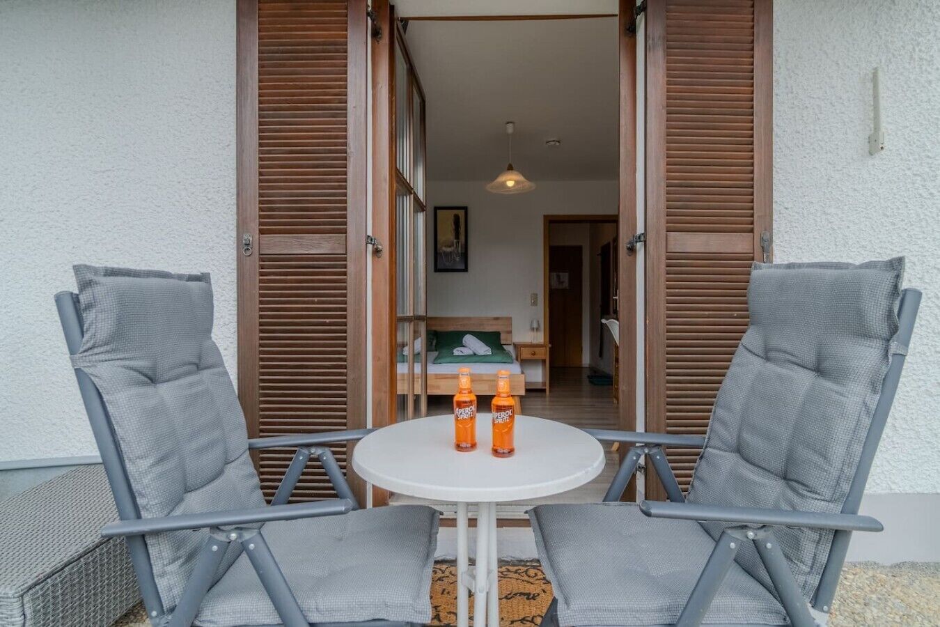 Ein Zimmer mit einem Bett, einem Nachttisch und einem Fenster.
