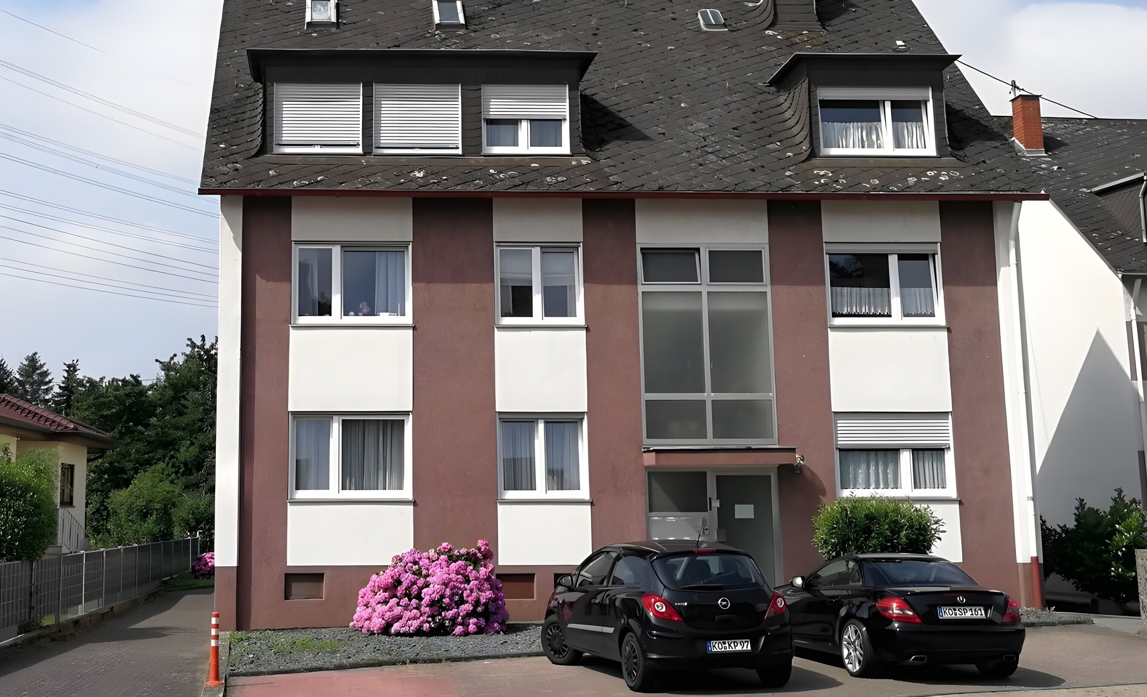 Un immeuble résidentiel à plusieurs étages, doté d’un toit plat, de grandes fenêtres et d’une entrée bien visible.