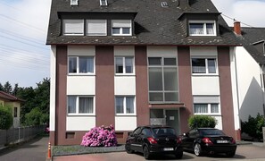 A multi-story residential building with a flat roof, large windows, and a visible entrance. - Apartment 'Haus Abendsonne Top Floor' with Terrace, Garden & Wi-Fi (Koblenz)
