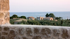 A coastal village with stone buildings, some with tiled roofs, and a view of the sea. - Kamak Villa I (West Mani)