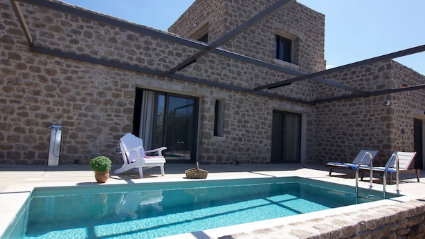 A stone building with a swimming pool, outdoor seating, and a potted plant. - Kamak Villa I (West Mani)