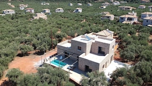 A stone house with a swimming pool, surrounded by olive trees and other vegetation. - Kamak Villa I (West Mani)