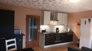 A compact kitchen with a microwave, stove, and coffee maker. - Apartment 'Haus Abendsonne Großes Hochparterre' with Private Terrace, Shared Garden and Wi-Fi (Koblenz)