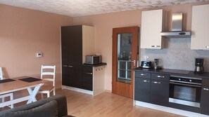 A compact kitchen with a microwave, toaster, coffee maker, and a built-in oven. - Apartment 'Haus Abendsonne Großes Hochparterre' with Private Terrace, Shared Garden and Wi-Fi (Koblenz)