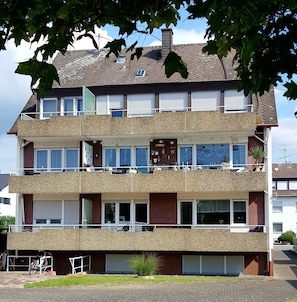 A multi-story residential building with balconies, windows, and a garage. - Apartment 'Haus Abendsonne Souterrain' with Shared Terrace and Wi-Fi (Koblenz)