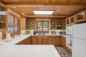 A kitchen with wooden cabinets, a white countertop, and a built-in oven.