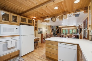 A kitchen with wooden cabinets, a microwave, a refrigerator, and a dishwasher.