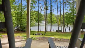 A view from a covered area with wooden chairs facing a lake surrounded by trees. - Lake, Mountain & Fall Colors-Your Hallmark-Moment (Cullowhee)