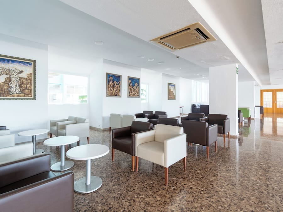 Een moderne lobby met zithoeken, kunstwerken aan de wanden en een glanzende vloer.
