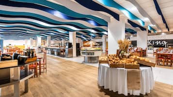 Un restaurant moderne doté d’un buffet central et de plusieurs espaces de restauration.