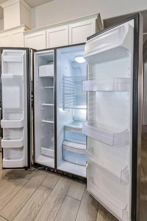 Eine moderne Küche mit weißen Schränken und einem eingebauten Kühlschrank.