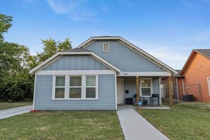A single-story house with a grey siding exterior, a front porch, and a visible number '1019' on the house.