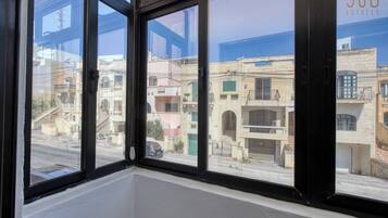 A room with large windows offering views of neighboring buildings.