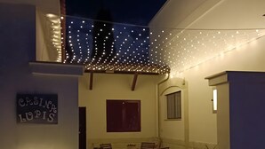 A courtyard with a dining area, string lights, and a sign that reads 'CASINO LOPIS'.