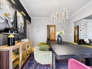 Un comedor moderno con una mesa de madera oscura, una silla tapizada en verde y un jarrón con flores.