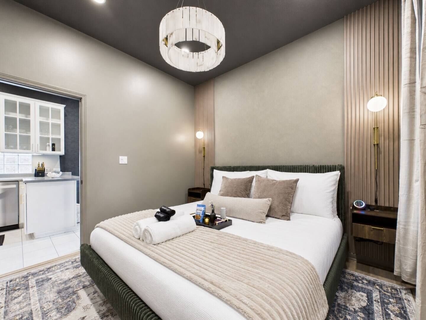 Ein Hotelzimmer mit Bett, Nachttischen, einem Schreibtisch und einem fenster mit Vorhängen.