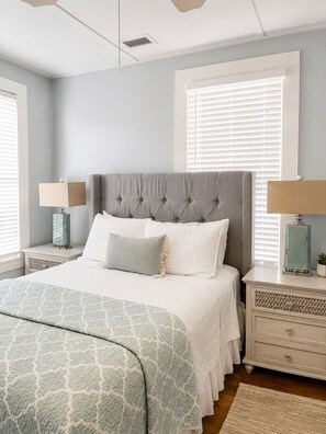 A bedroom with a bed, nightstands, a dresser, and a window with blinds. - Uptown 2nd story APT - blocks from the fort! (St. Augustine)