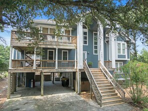 A multi-story house with a balcony, a staircase, and a covered porch area. - Village at Ocean Hill 26: Pool | Nearby Beach (Corolla)