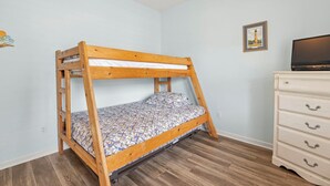A bunk bed with a patterned mattress, a dresser with drawers, and a framed picture on the wall. - I'm Lov'n Sea and Sand: Dog Friendly | 4Br (Corolla)