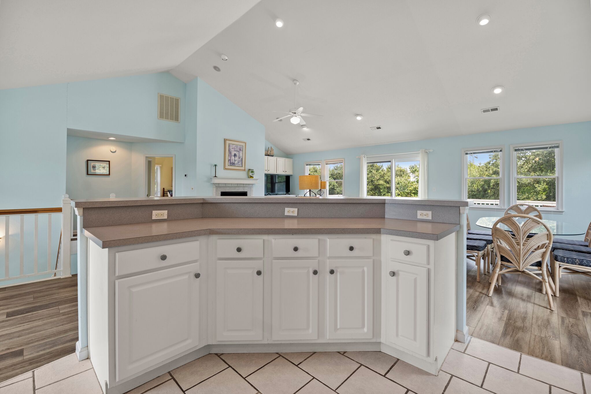 A kitchen with white cabinets, a granite countertop, and a ceiling fan.