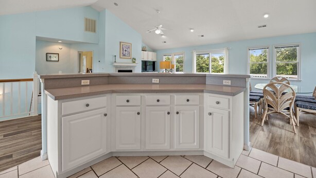 A kitchen with white cabinets, a granite countertop, and a ceiling fan. - I'm Lov'n Sea and Sand: Dog Friendly | 4Br (Corolla)