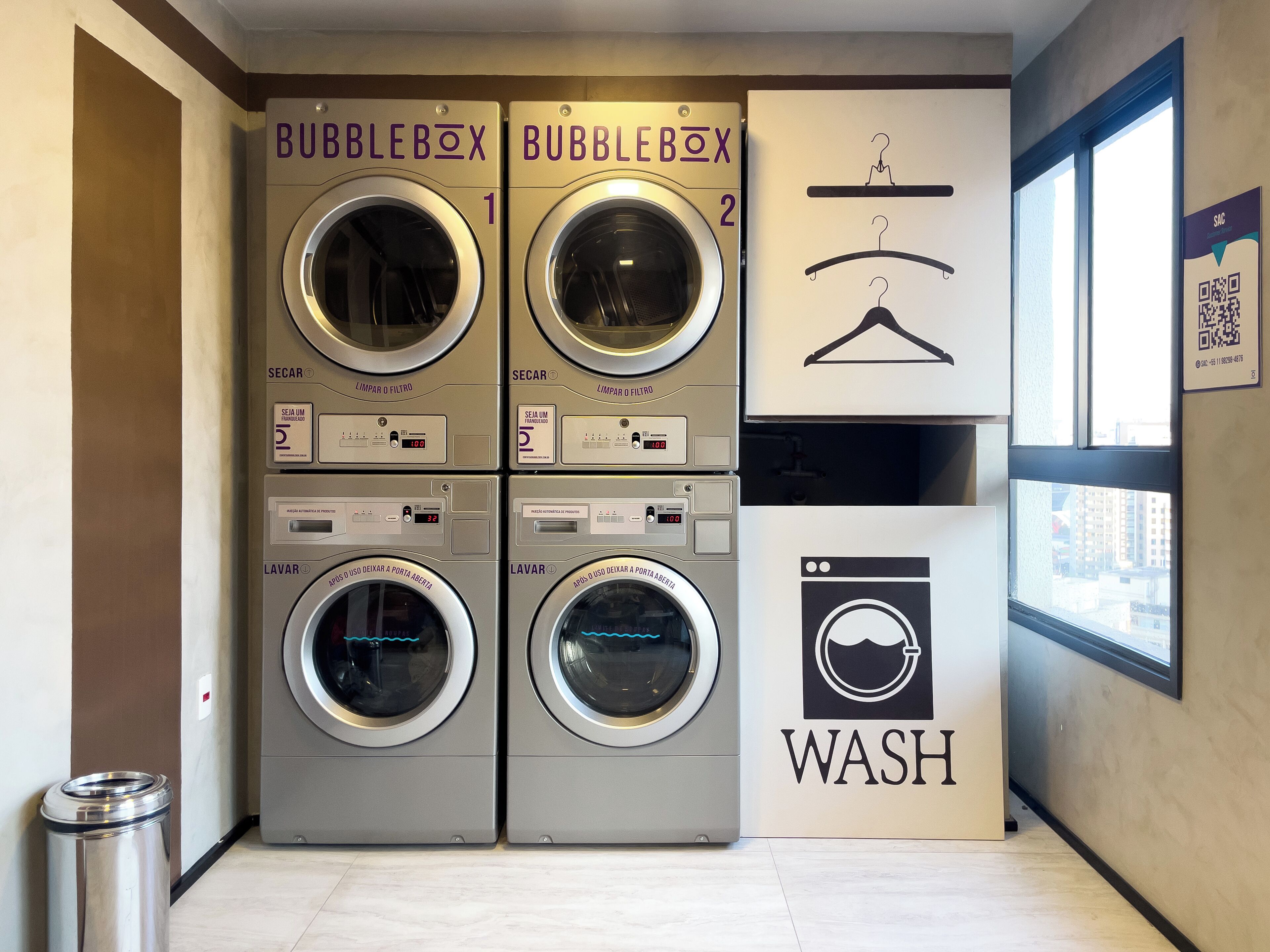 A laundry facility with four washing machines labeled 'BUBBLEBOX' and a 'WASH' sign.