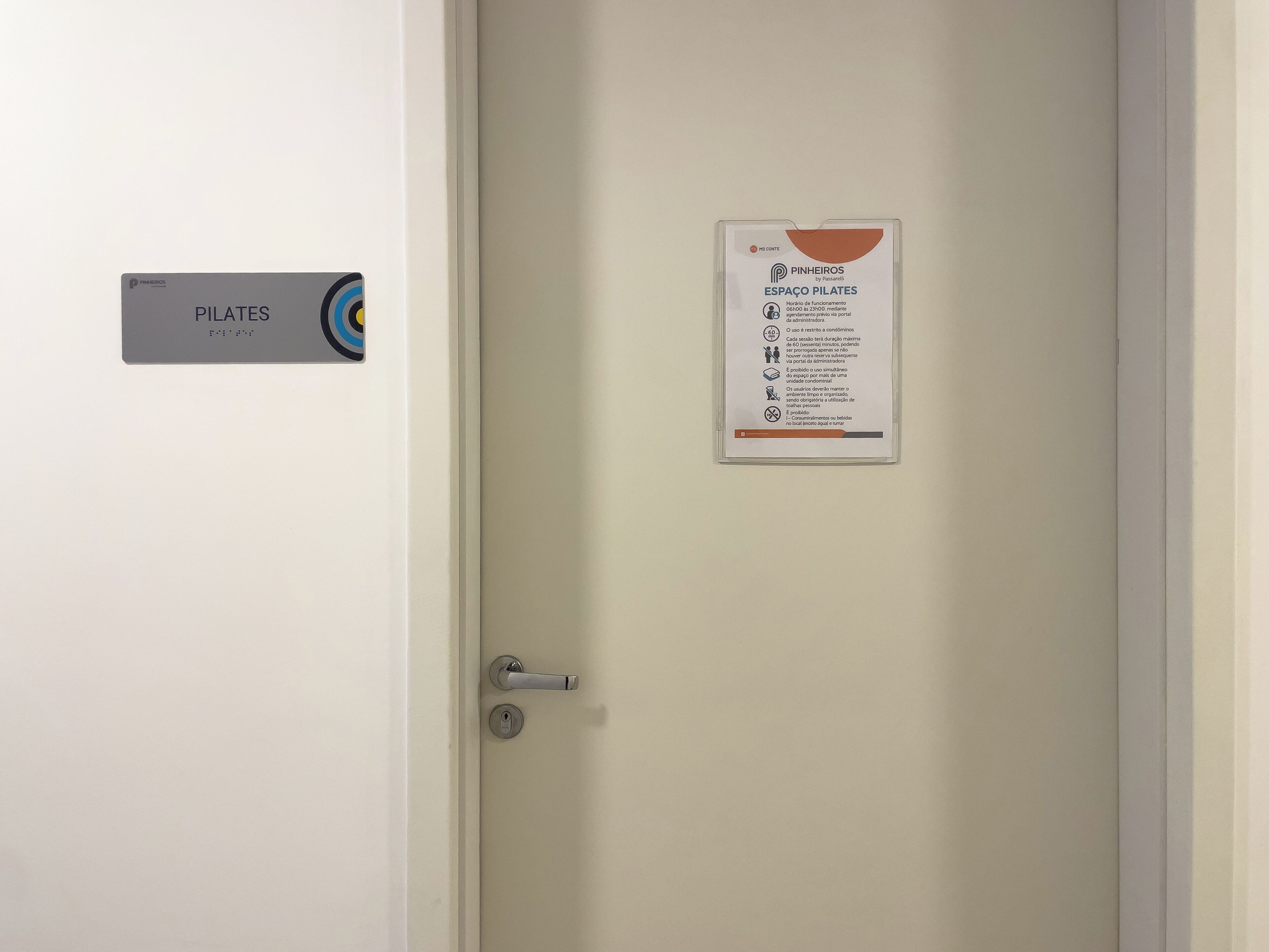 Una puerta con un letrero que indica una sala de Pilates y otro con instrucciones de uso.