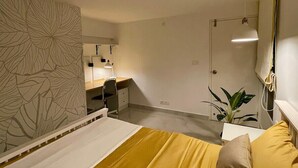 A bedroom with a bed, a desk, and a chair. There is a plant on the desk. - Entire rental unit in Bengaluru, India (Bengaluru)
