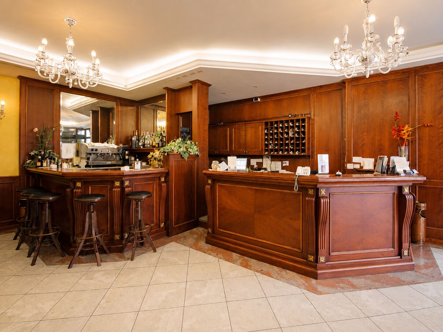 A bar area with wooden paneling, a coffee machine, and bar stools.